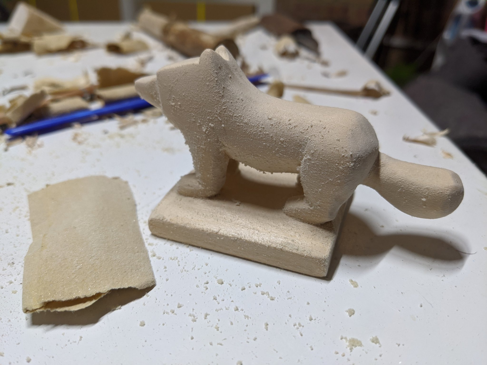 Sandpaper next to the dog, with the dog covered in a soft fluff like appearance after being sanded