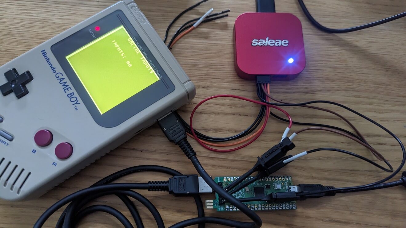 A Game Boy with a game link connected into a Raspberry Pico with a logic analyser connected