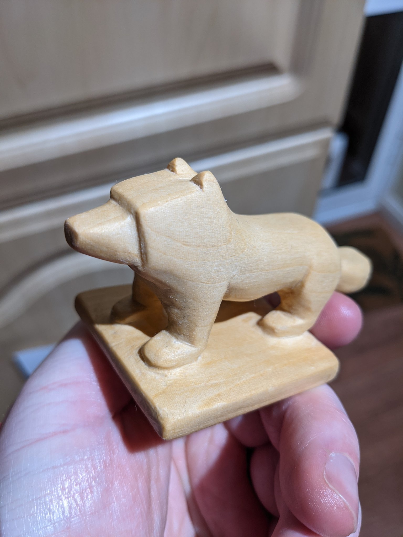 Side view of the finished dog, all edges look soft to touch and the wood grain can be clearly seen on the final golden finish